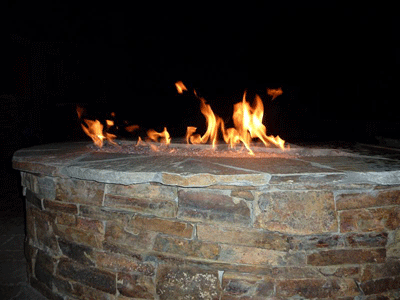 custom stone fire pit with burning glass